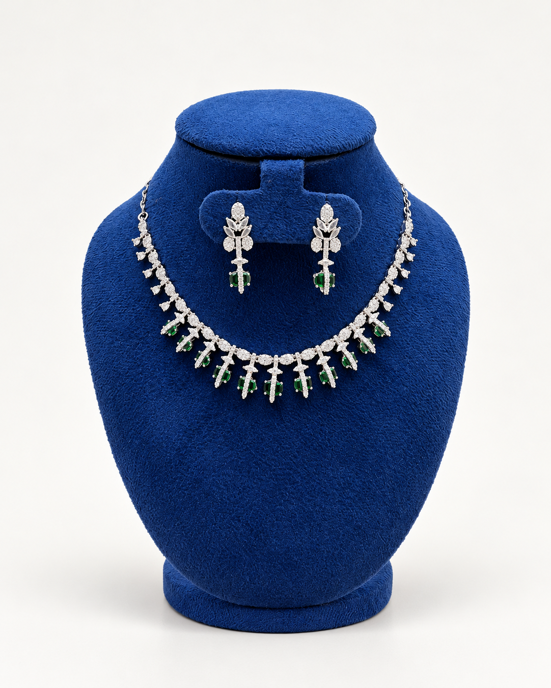 Kaveri floral fringe necklace set with earrings in green on a blue velvet display stand