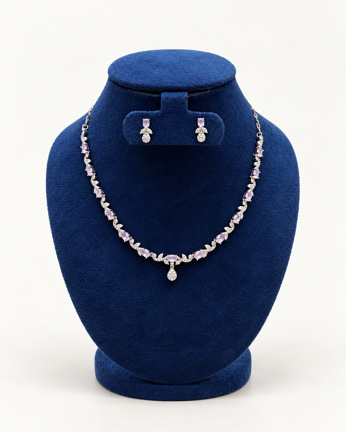 Kaveri leaf vine necklace set with petite earrings in pink on a blue velvet display stand