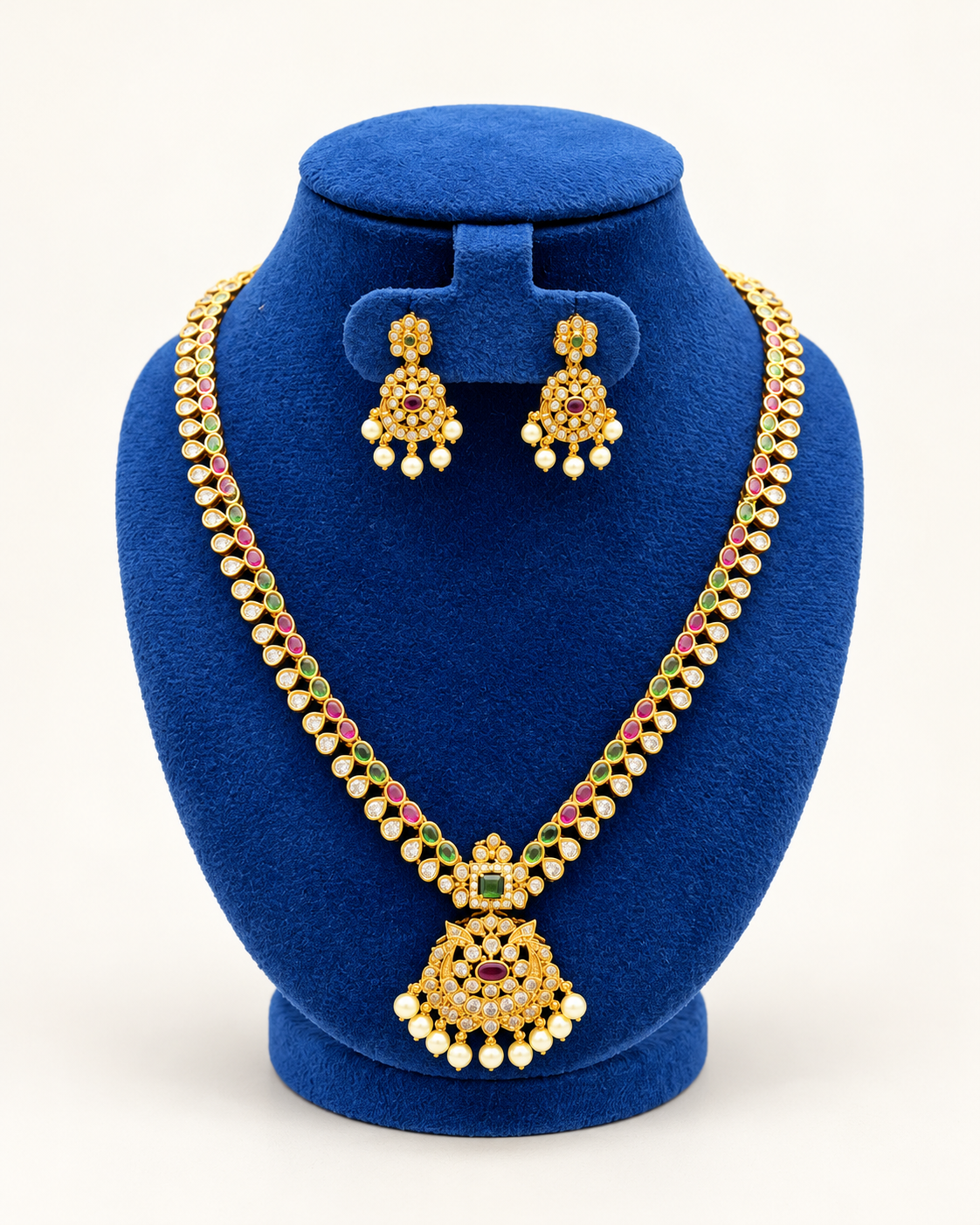 Kaveri long leaf stone pearl pendant necklace set with earrings in multicolor on a blue velvet display stand