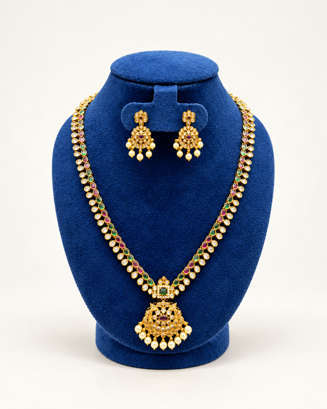 Kaveri long leaf stone pearl pendant necklace set with earrings in multicolor on a blue velvet display stand
