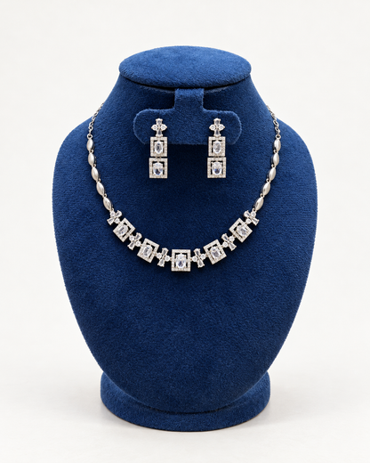 Kaveri square halo necklace set with long earrings in clear on a blue velvet display stand