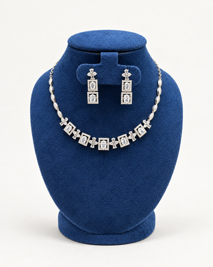 Kaveri square halo necklace set with long earrings in clear on a blue velvet display stand